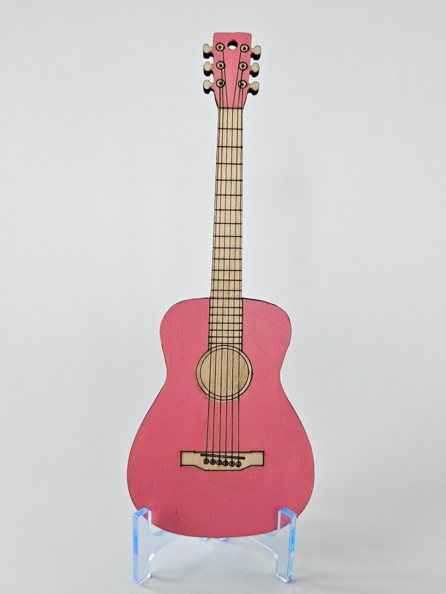 Wooden mini cello on a clear stand with white background.