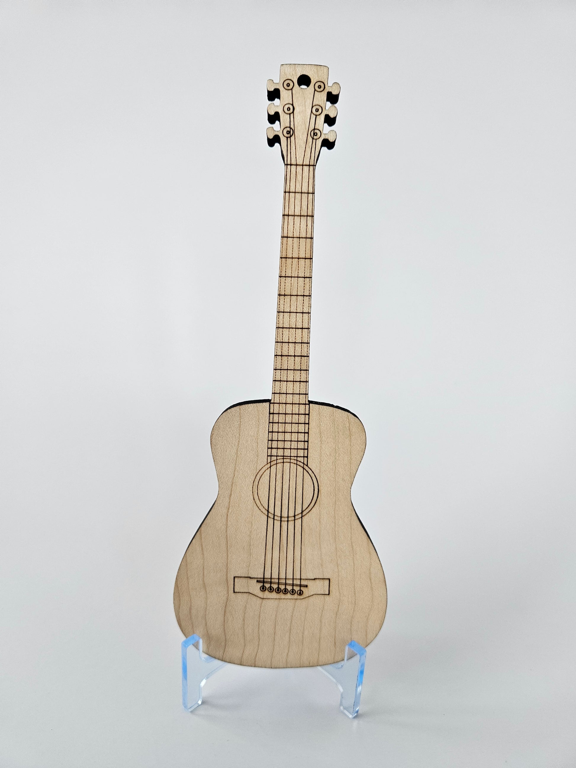 Wooden mini acoustic guitar with a clear protective cover on a light gray background