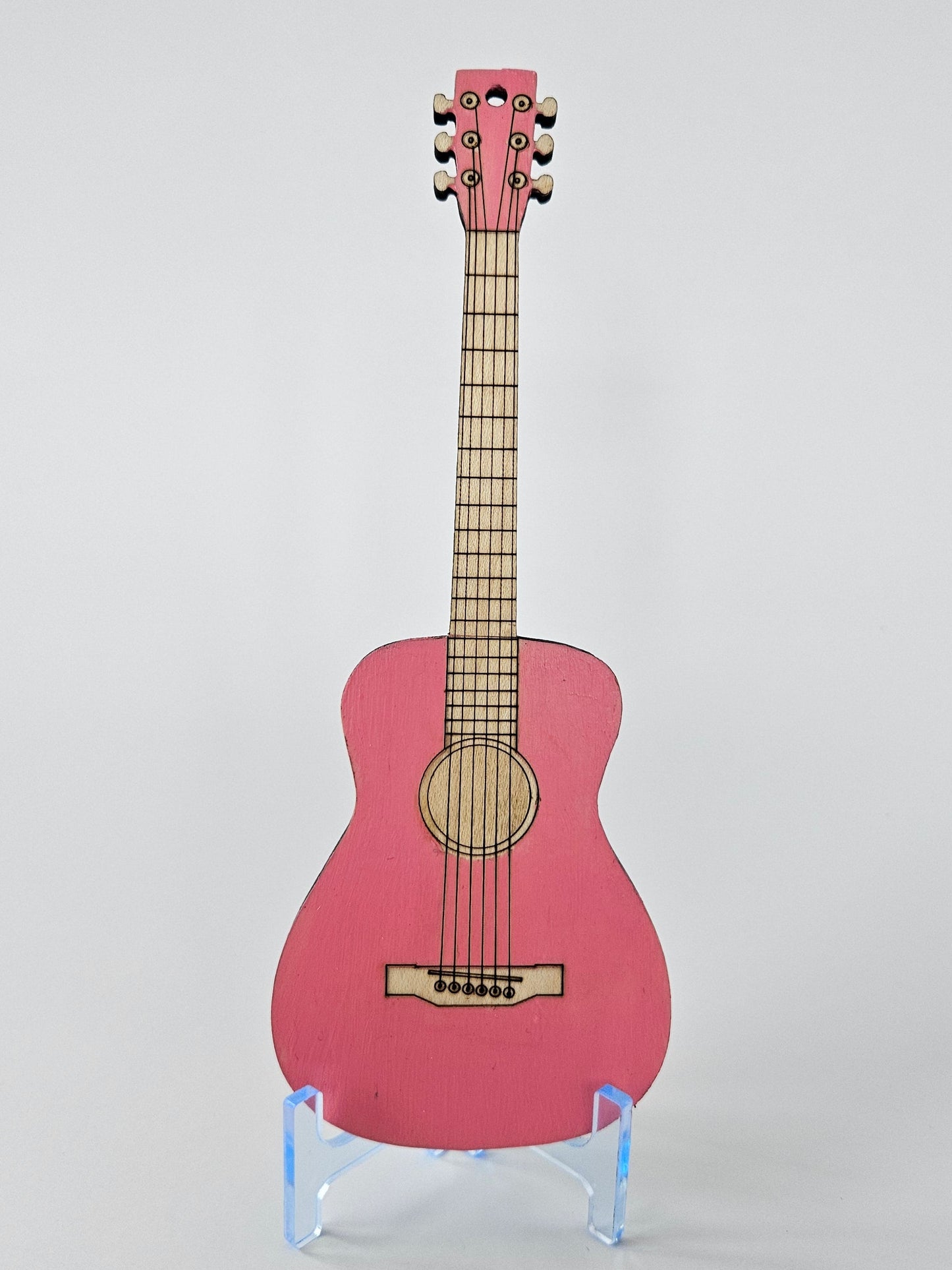Small pink guitar on a white background