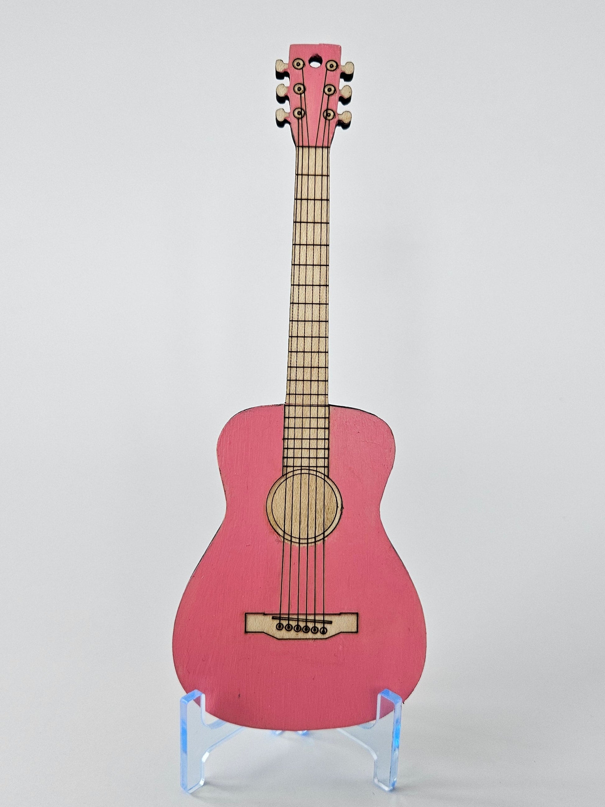 Small pink guitar on a white background