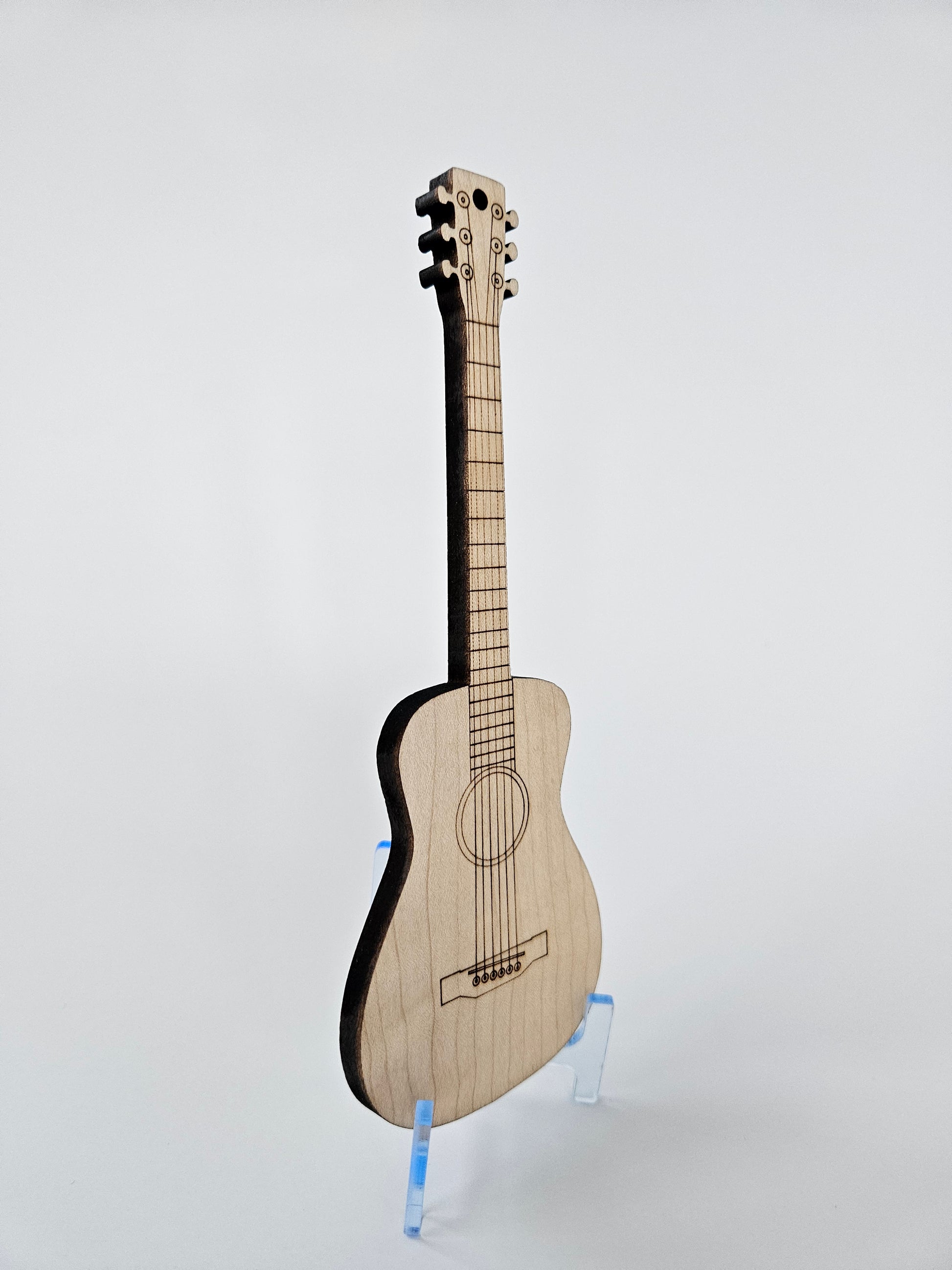 Side view of small wooden guitar on a light gray background